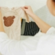 Celebrating the miracle of life: A woman lovingly holds a tiny onesie, symbolizing the precious new life made possible through her generous egg donation, bringing hope and happiness to intended parents and families affected by infertility.